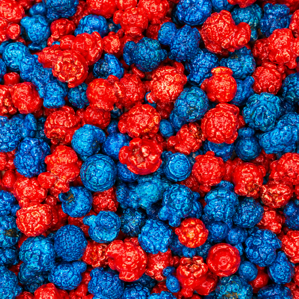 A close-up, top-down view of red and blue popcorn kernels filling the entire frame.