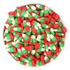 Assorted red, green, and white candy corn in a white bowl on a white background